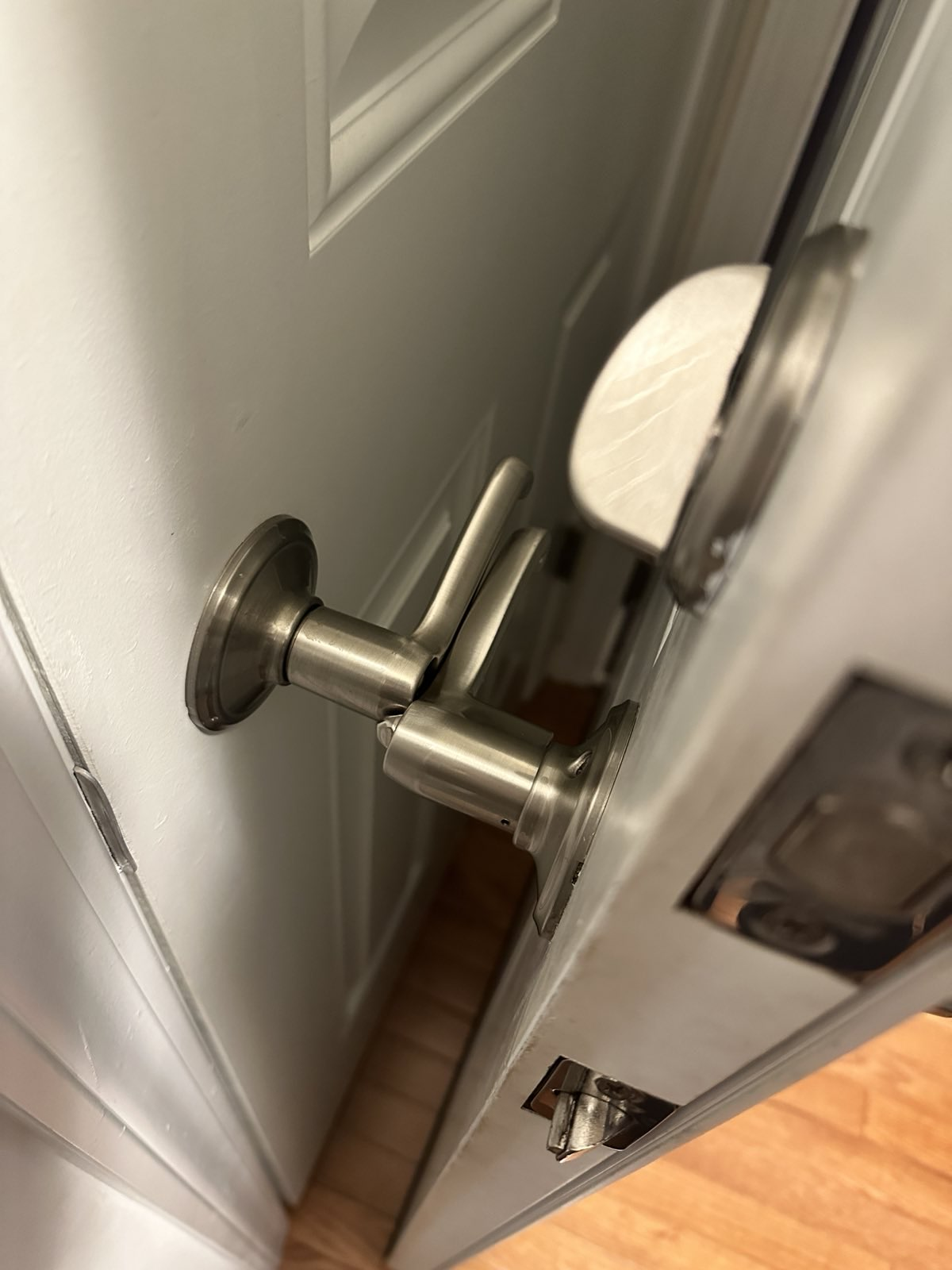 A photograph of two door handles touching each other when one door is opened fully.